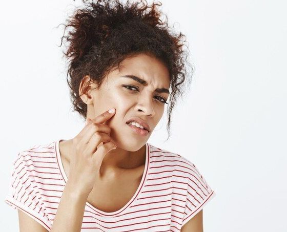  displeased unhappy woman with curly hairstyle posing in the studio