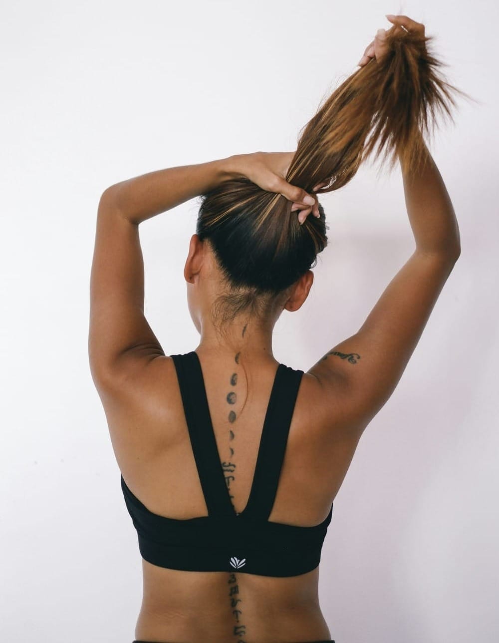 woman in black exercise tank top showing her back