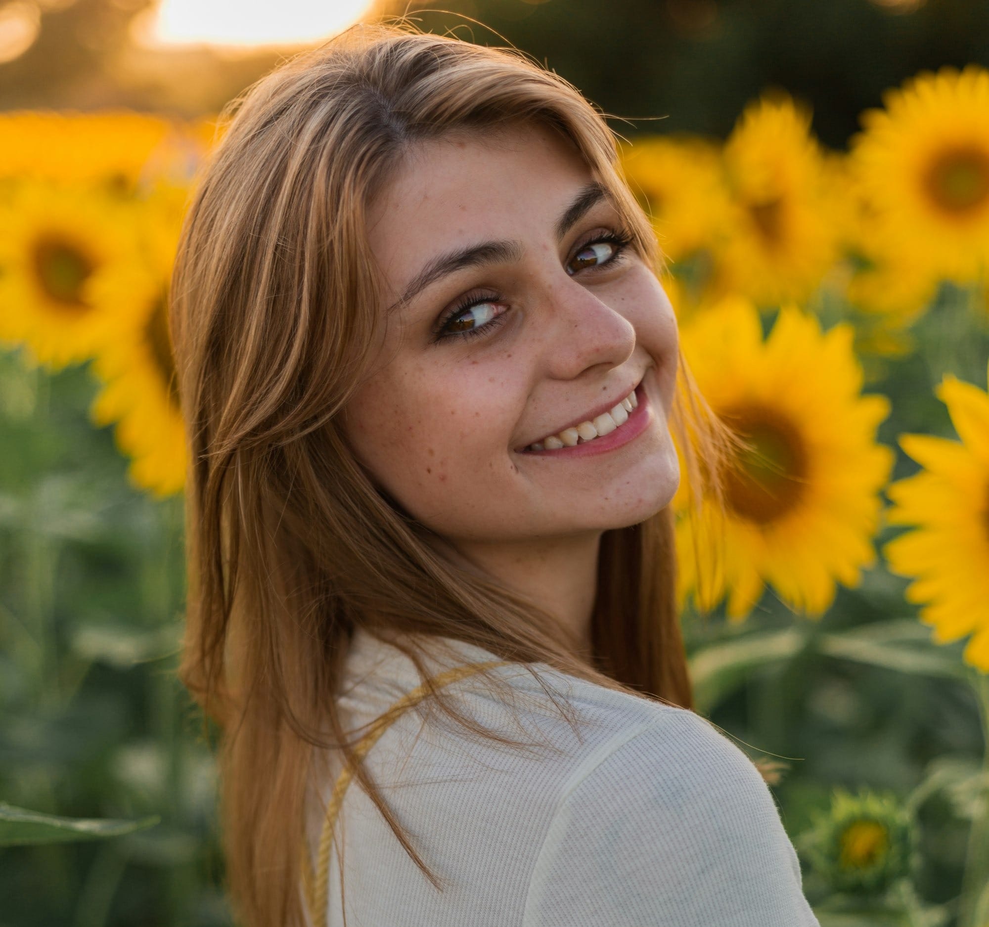 smiling woman in white beside yellow flower during daytime - Acne Spot Treatments: Salicylic Acid vs. Benzoyl Peroxide for Clear Skin