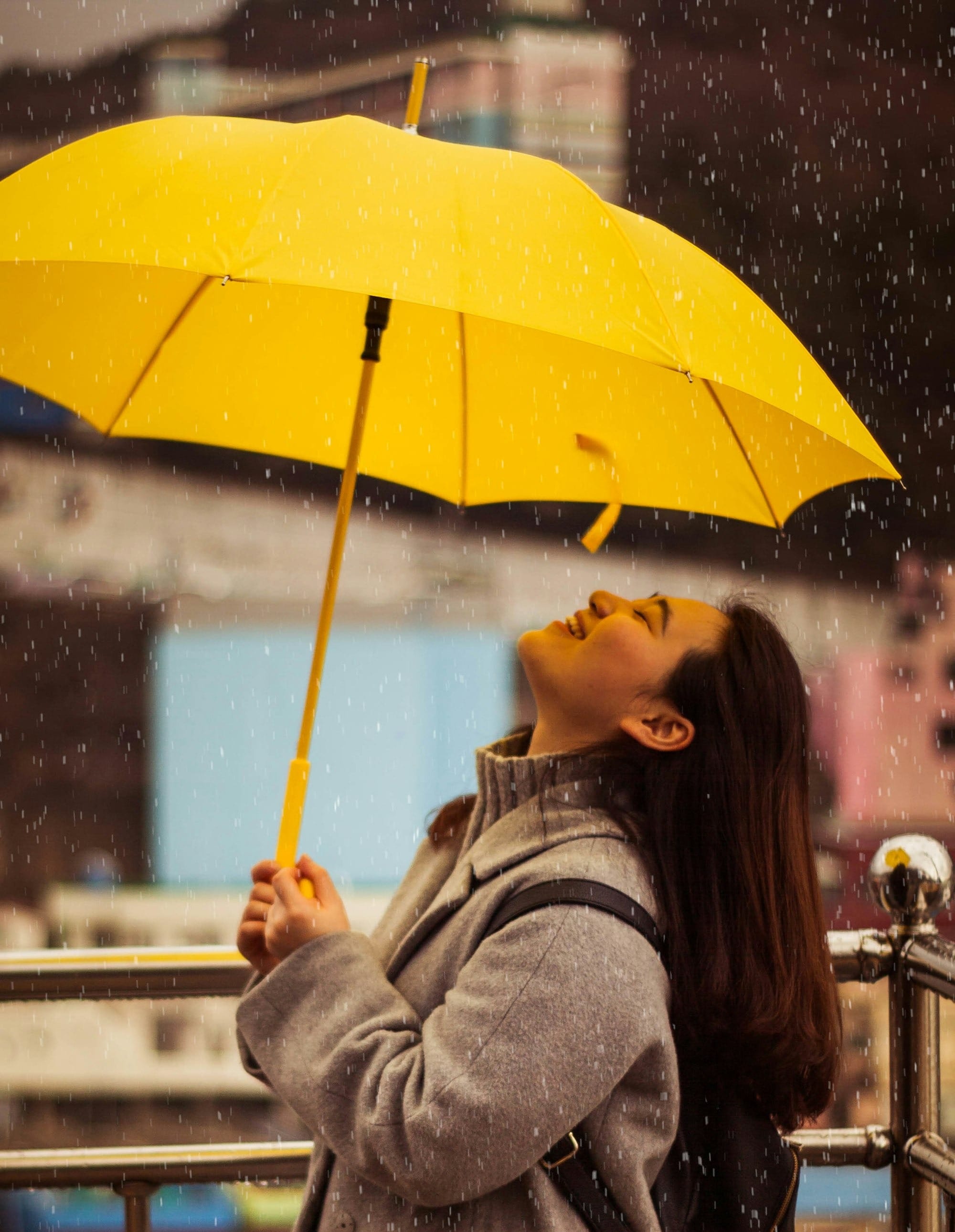 woman in gray jacket holding yellow umbrella - Korean Vitamin C Serums 