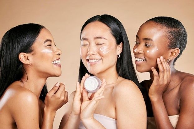 three girls with face product on beige background - Korean Skincare for Dry Skin