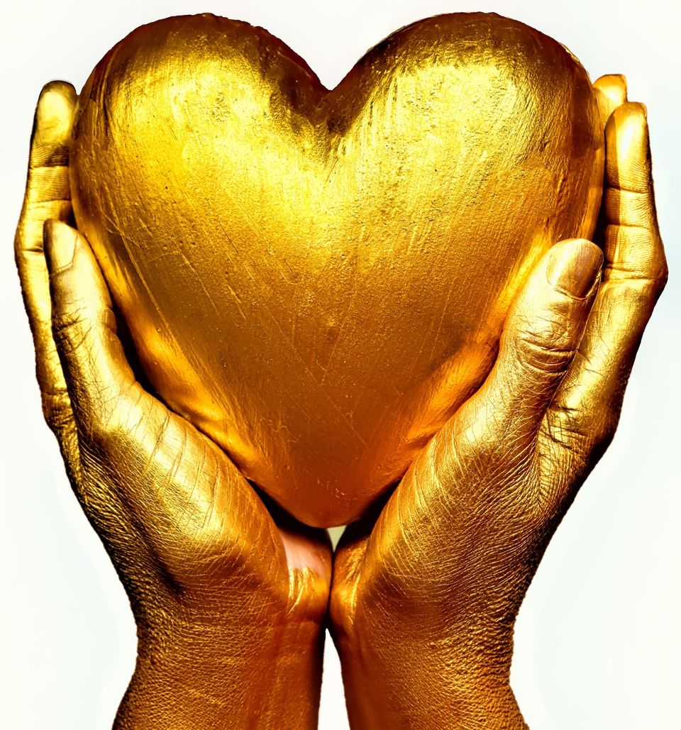 hands painted gold holding golden heart shape - celebs and gold face masks