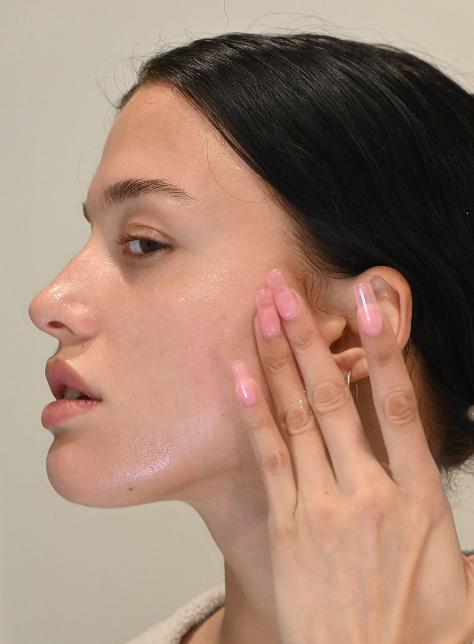 Adult Acne: Over-the-Counter Solutions To Help You Take Control - girl with pink nails applying product on her face