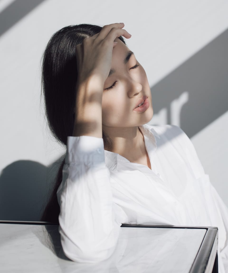 Asian featured girl under gazebo filtered sunshine in white on grey background