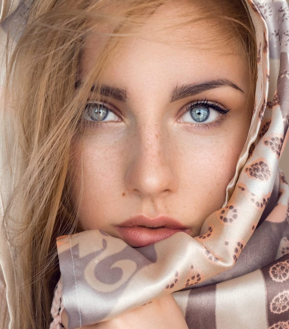 girl with blond hair and freckles and roseacea holding head scarf - Best Azelaic Acid Serums