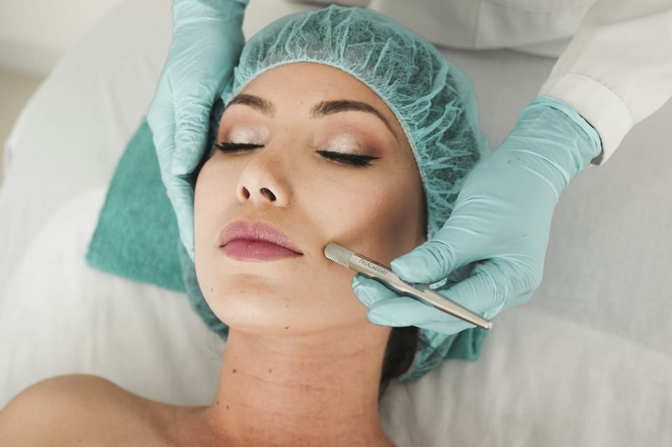 Micro current facial device use with girl on treatment table