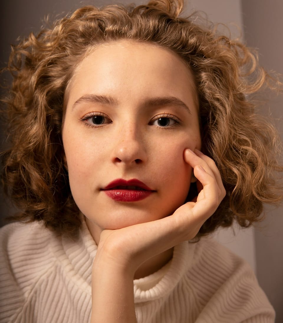 closeup image of girl holding her chin - Acne Myths: Separating Fact from Fiction in Skincare & Breakouts