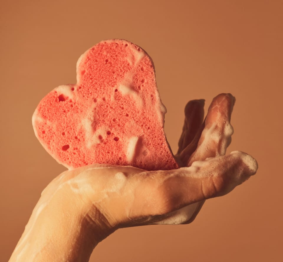 hand holding soap sponge - Shower Gel vs. Body Wash